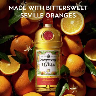 Eine Flasche Tanqueray Flor de Sevilla Destillierter Gin mit Orangengeschmack liegt in Orangen