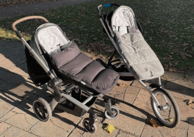 KETTLER Baby & Kinder 3-in-1 Fußsack in zwei verschiedenen Kinderwägen auf einem Fußweg in einer Grünfläche