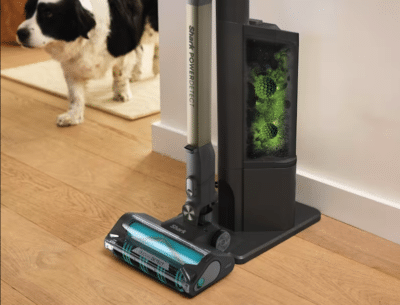 Shark PowerDetect Clean & Empty Akku-Staubsauger für Tierhaare mit Entleerungsstation im Flur vor einem Hund